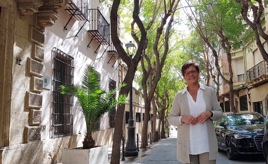 Adriana paseando por una calle del centro histórico de Almería. Álboles sombrean la calle.